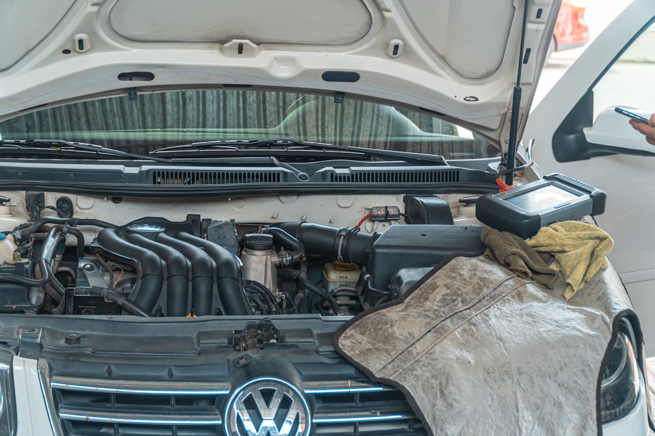 Close-up of a Volkswagen car engine undergoing repair in a garage, tools and diagnostic equipment in use.